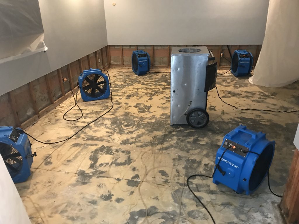 Water Damage Restoration - Midlands Restoration Services A room filled with mitigation drying equipment and abundant water.